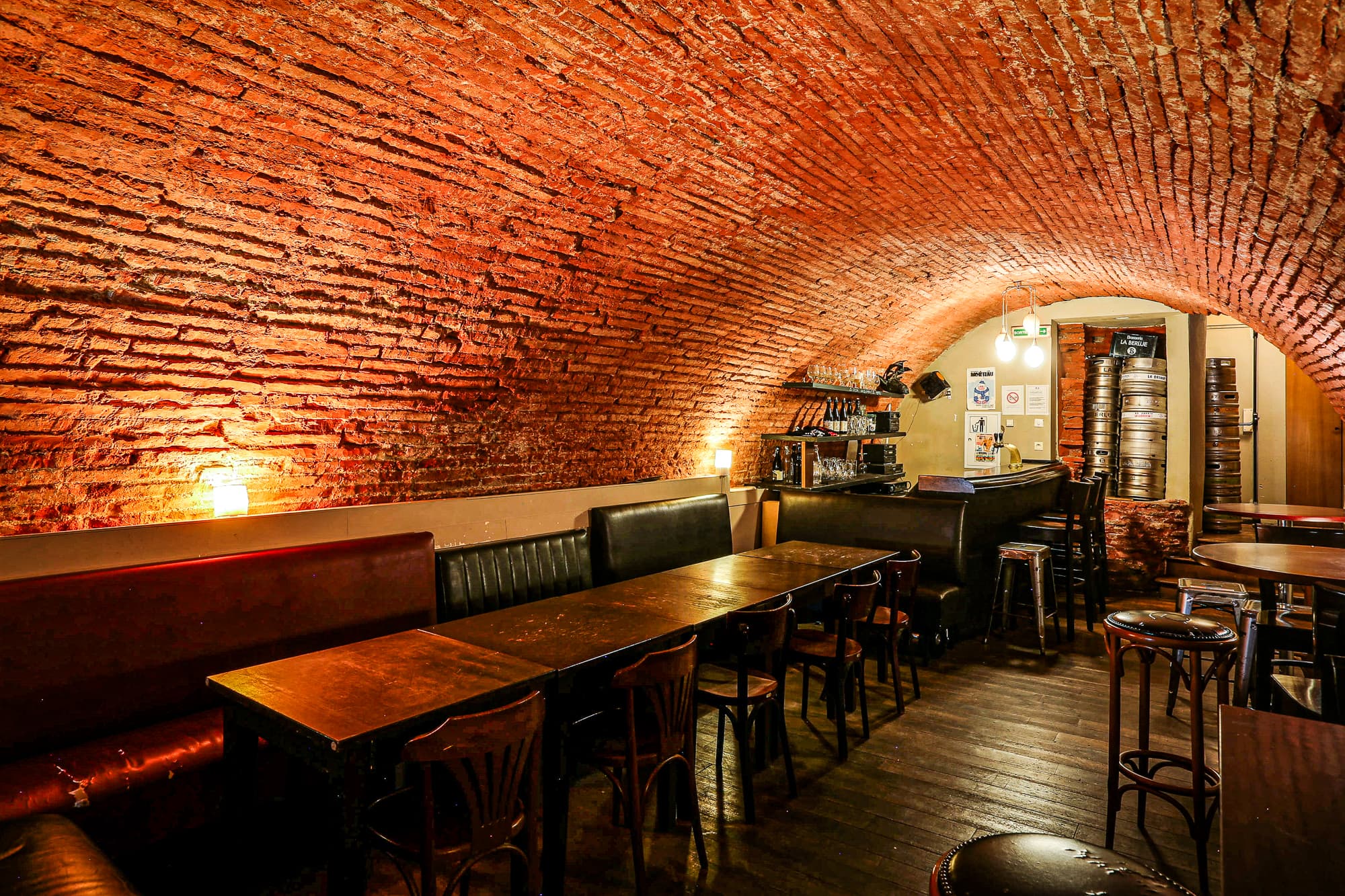 The vaulted cellar bar counter with stacked beer kegs